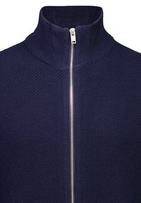 Marinblå zip-up-tröja med hög krage, texturerad tyg och silverfärgad dragkedja. Har ett rutformat mönster över hela plagget.
