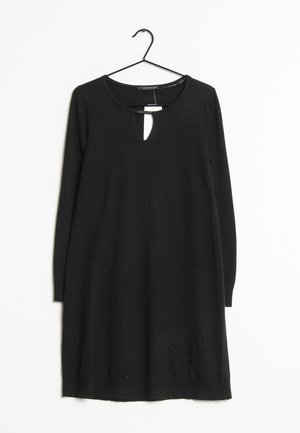 Schwarzes langärmliges Kleid mit einem Schlüsselloch-Ausschnitt, das an einem schwarzen Haken hängt. Hergestellt aus weichem Stoff, mit lässiger Passform und knielangem Design.