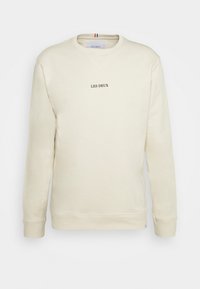 Light beige sweatshirt made of soft fabric, featuring a V-neck, ribbed cuffs, and "LES DEUX" embroidered in dark brown at the center.