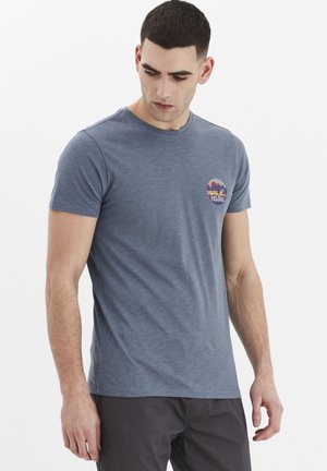 Tricou cu mânecă scurtă, de culoare albastră, confecționat dintr-un material ușor, cu un grafic mic rotund ce prezintă palmieri și un apus de soare în culori vibrante.
