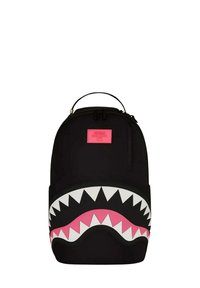 Mochila negra con un gran gráfico de boca de tiburón con dientes blancos y un interior rosa. Incluye un asa en la parte superior y un compartimento con cremallera.