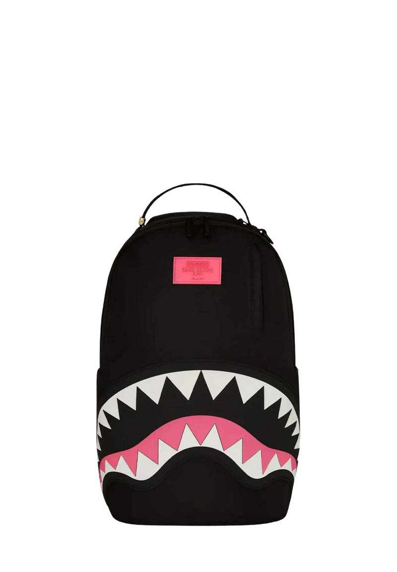 Mochila negra con un gran gráfico de boca de tiburón con dientes blancos y un interior rosa. Incluye un asa en la parte superior y un compartimento con cremallera.