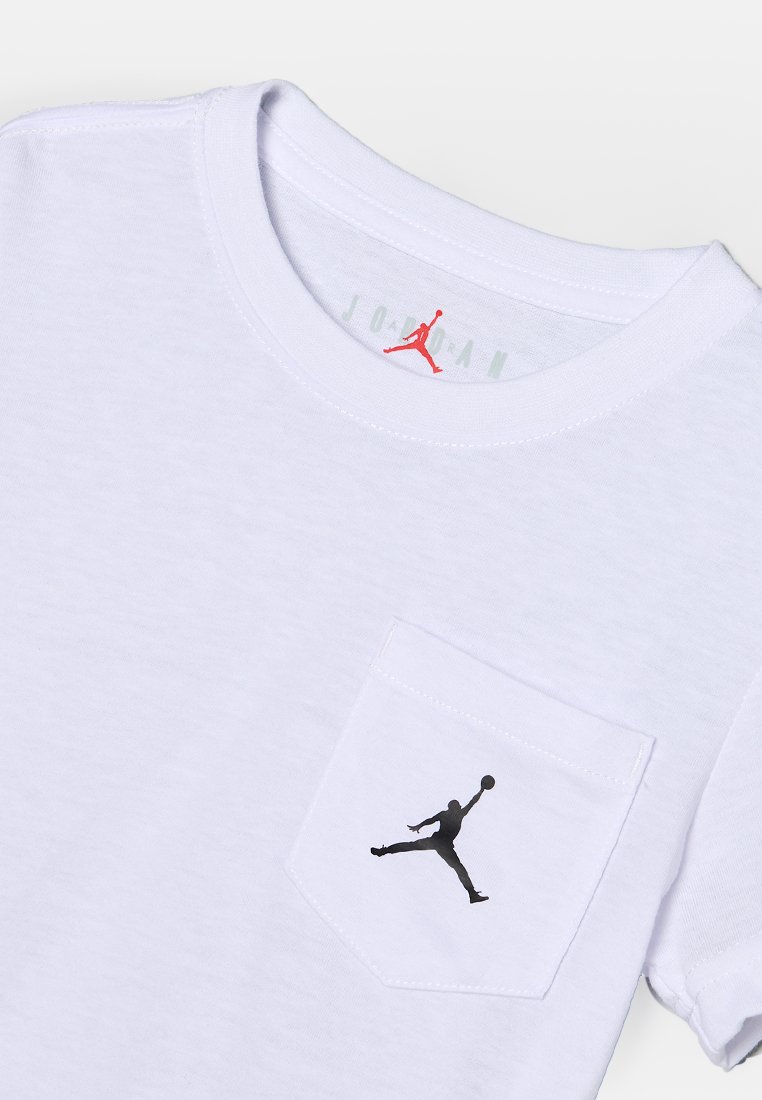 Biała bawełniana koszulka z czarnym logo Jordana na lewej kieszeni. Gładka struktura z klasycznym okrągłym dekoltem i krótkimi rękawami.