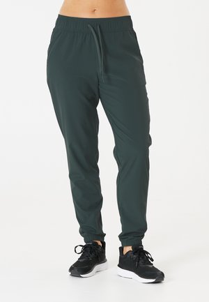 Joggers extensibles, de couleur vert foncé, avec une taille élastique et un cordon de serrage ajustable. Poignets aux chevilles et tissu léger et doux.