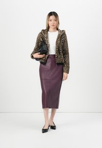 Leopard print faux fur jacket, white top, and a form-fitting purple leather pencil skirt, paired with black flats and a black bag.