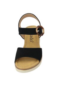 Czarne zamszowe sandały z szerokim paskiem na stopie i okrągłą klamrą. Beżowa wkładka i jasna podeszwa, zdobione prostym przeszyciem.