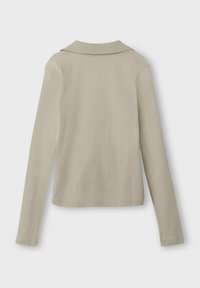 Beige ribbad långärmad topp med en mjuk krage. Har en figurnära design och en strukturerad tyg. Ren, enkel konstruktion utan mönster.