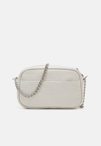 Bílá kožená crossbody taška s krokodýlím vzorem. Obsahuje stříbrný řetízek a má obdélníkový tvar s přední kapsou.