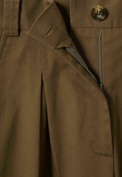 Pantalones marrones ajustados con cremallera y botón, con líneas limpias, pliegues en la parte delantera y una textura de tela suave y resistente.