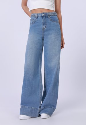 Jeans a gamba larga di colore blu chiaro con cintura intrecciata, caratterizzati da un classico design a cinque tasche e una leggera texture sbiadita.