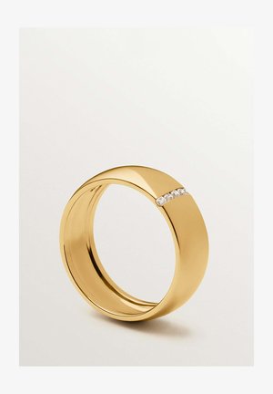 Anillo de banda dorada con un acabado liso que presenta una fila horizontal de pequeñas piedras preciosas transparentes incrustadas en un lado.