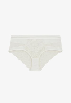 Culotte en dentelle blanche avec des bords festonnés, présentant des motifs floraux et une taille lisse. Fabriquée à partir d'un mélange de dentelle et de tissu.