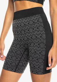 Hochtaillierte schwarze Trainingsshorts mit einem strukturierten grauen geometrischen Muster. Verfügt über ein glattes Material und einen breiten elastischen Bund.