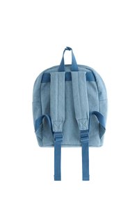 Ανοιχτό μπλε υφασμάτινο σακίδιο με επενδυμένη πλάτη, ρυθμιζόμενους ιμάντες και χειρολαβή στην κορυφή. Λείος υφασμάτινος, στρογγυλεμένο σχήμα και μινιμαλιστικός σχεδιασμός.