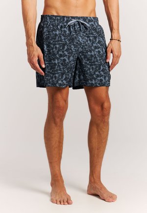 Shorts de bain bleu marine à motif de feuilles de palmier, en tissu léger. Dotés d'une taille élastique avec cordon de serrage et de poches latérales.