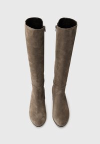 Bottes montantes en suède taupe doux avec une texture lisse, dotées d'une fermeture éclair sur le côté pour un enfilage facile et d'un design à bout rond.