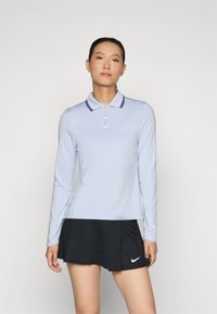 Light blue long-sleeve polo shirt with a solid pattern, featuring a contrasting dark blue collar and button placket, paired with a black skirt.