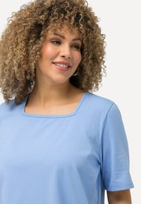 Lichtblauw kort mouwtopje met een vierkante halslijn, gemaakt van een gladde stof, met een ontspannen pasvorm en subtiele stikseldetails.