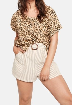 Krótka bluzka w panterkę w odcieniach beżu i brązu; zestawiona z białymi i beżowymi szortami w paski z wysokim stanem, ozdobionymi brązowym, okrągłym paskiem.