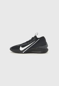 Crni atletski tenisice s reljefnom gornjom, bijelim Nike logotipom i kontrastnim crnim potplatom. Imaju vezice i stražnji povlačni trak.