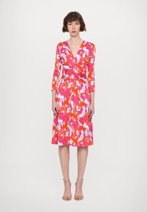 Robe longueur genoux avec des motifs en rose vif, orange et bleu clair. Elle a des manches longues et un design enroulé avec une taille froncée.