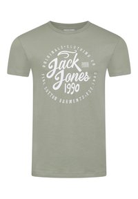 Camiseta de algodón verde claro con un estampado gráfico blanco que incluye "Jack & Jones" y "1990" en una tipografía negrita. Diseño de manga corta y cuello redondo.