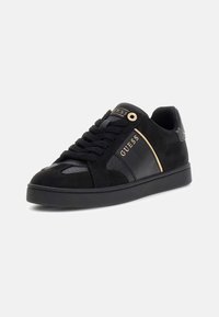 Adidași negri din suede și piele, cu accente aurii, un vârf texturat și un design cu șireturi.