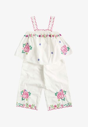 Ensemble blanc pour tout-petit avec broderie florale rose et verte, bretelles festonnées et pantalon assorti avec ourlets brodés.