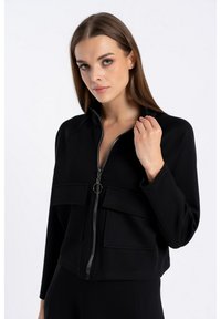 Czarna krótka kurtka z miękkiego materiału, z suwakiem w kolorze srebrnym, dwoma przednimi kieszeniami i wysokim kołnierzem dla nowoczesnego wzornictwa.