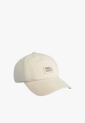 Beige cotton baseball cap with curved brim and a rectangular label reading "REELL Established 1987" on the front panel.