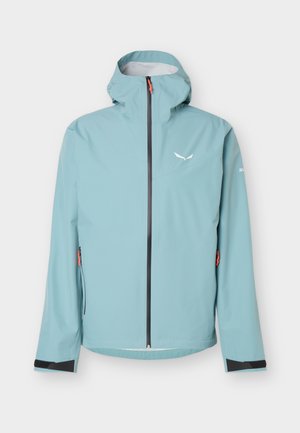 Šviesiai mėlyna vandeniui atspari striukė su gobtuvu, juodas užtrauktukas ir mažas baltas logotipas ant krūtinės, užsegamos šoninės kišenės ir reguliuojamos rankogaliai.