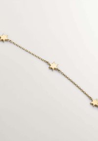 Pulsera de cadena dorada con acentos alternos en forma de estrella. Las estrellas tienen superficies lisas con puntas afiladas, unidas a una delicada cadena.