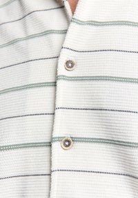 Witte shirt van textuurstof met horizontale strepen in groen en marineblauw. Opvallende ronde knopen met gegraveerd logo-detail.