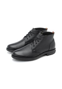 Zapatos de cuero negro con un acabado texturizado, puntera redondeada y diseño con cordones. Presentan un corte bajo y suela de goma resistente para mayor durabilidad.