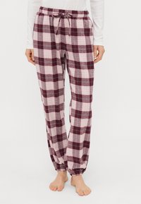 Πιτζάμες σε ροζ και μπορντό καρώ, με ελαστική μέση, κορδόνι και ελαστικούς μανσέτες στον αστράγαλο. Μαλακή υφή υφάσματος.