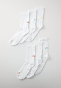 Chaussettes en coton blanches avec une texture côtelée, arborant le logo "PUMA" dans des couleurs pastel : rose, bleu et jaune sur différentes paires.