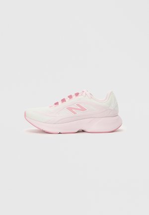 Pantofă de alergare New Balance de culoare roz deschis și alb, cu partea superioară din plasă și talpă amortizată, văzută din lateral pe un fundal alb simplu.