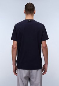 Mørkeblå bomulds t-shirt med rund hals og korte ærmer. Enkel, glat tekstur med diskret branding ved nakken bagpå.