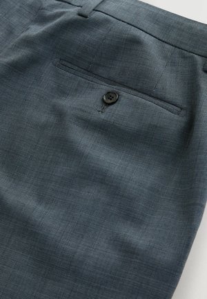 Dark gray tekstuuriga kleitpükste lähiümbris, tagatasku, millel on üks must nööp ja selle kohal vööaas.