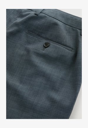 Dark gray tekstuuriga kleitpükste lähiümbris, tagatasku, millel on üks must nööp ja selle kohal vööaas.