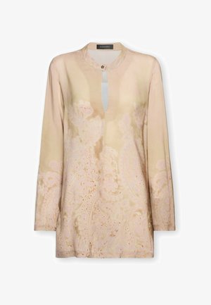 Blouse beige à manches longues avec des motifs floraux cachemire subtils, encolure ronde avec une fermeture à un bouton et une petite ouverture en forme de trou de serrure à l'avant.