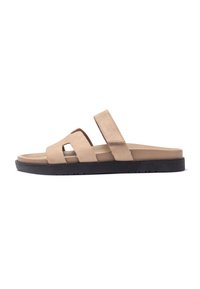 Beige Wildledersandalen mit schwarzer Gummisohle, ausgestattet mit zwei breiten Riemen und einem ausgeschnittenen Design für Belüftung und Komfort.