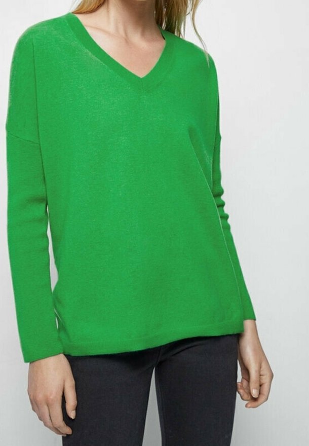 Green v-neck sweater with long sleeves, made of soft material, featuring a relaxed fit and simple design, paired with dark jeans.