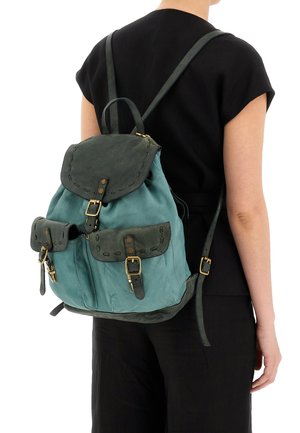 Zaino in pelle verde teal e verde scuro, dotato di chiusura a pattina, tasche frontali con fibbie e spallacci regolabili con dettagli in metallo dorato.