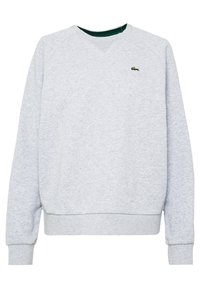 Sudadera gris con escote en V, mangas raglán y puños acanalados. Cuenta con un pequeño logo verde de Lacoste en el pecho. Está hecha de una suave tela texturizada.