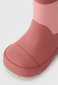 Botas de borracha em um design bicolor rosa e rosa-claro. Apresenta uma superfície texturizada e uma ponta arredondada com uma sola cinza claro para tração.