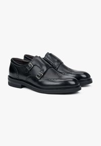 Czarne skórzane buty z dwoma klamrami, z teksturowanym wykończeniem, detalami w stylu brogue, okrągłym noskiem i niskim gumowym obcasem.