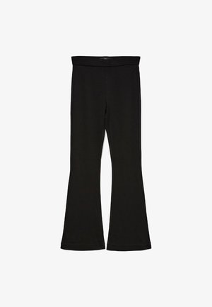 Schwarze Schlagleggings aus dehnbarem Stoff. Sie verfügen über einen breiten Bund und eine glatte Textur, mit einer enganliegenden Silhouette, die am Saum ausgestellt ist.