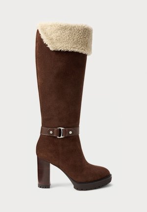 Stivale da donna in suede marrone alto con tacco alto a blocco, cinturino con fibbia, suola carrarmato e bordo superiore in pelliccia di shearling crema piegato.