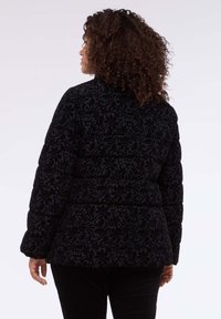 Czarna kurtka puchowa z wytłaczanym floralnym wzorem, wysokim kołnierzem i ściągaczami na mankietach. Projekt posiada taliowanie dla zdefiniowanego kształtu.